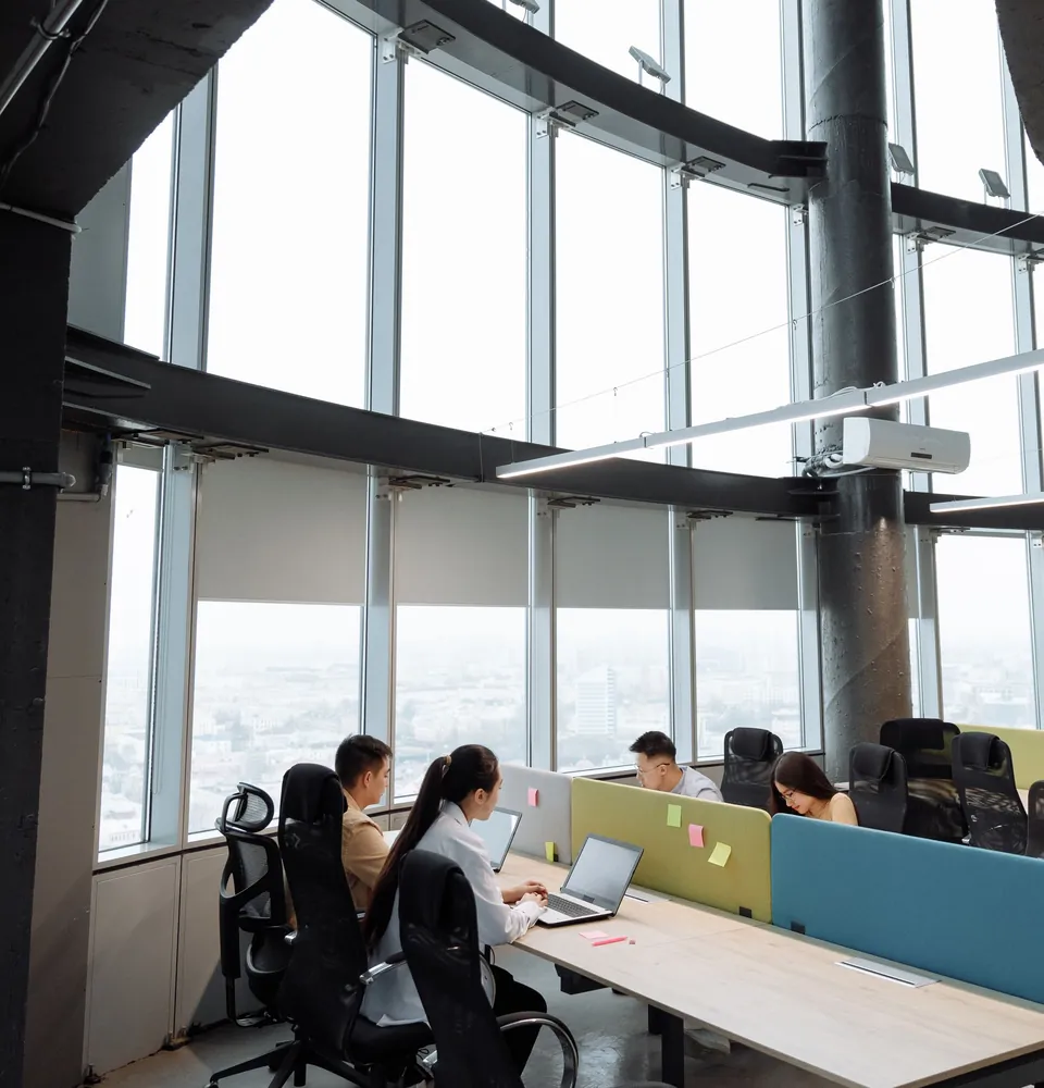 Bright, modern high-rise office with large windows and people working at their desks